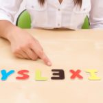 Dyslexia spelled out in magnetic letters with child