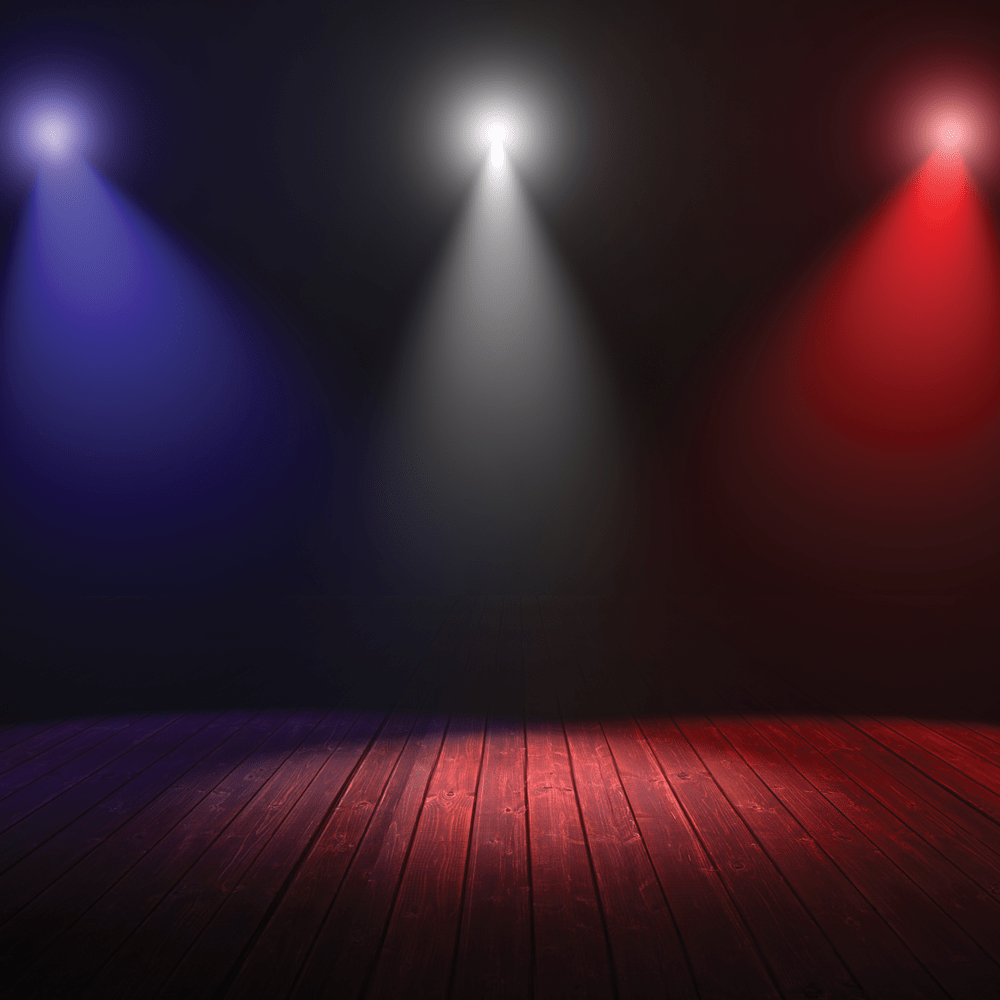Blue, white, and red spotlights are shining down on a darkened stage for Performing Artists. 