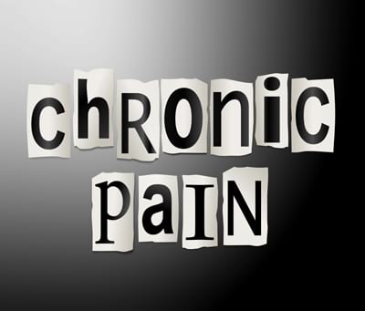 The words chronic pain spelled out in cut out letters on a black to white gradient background.