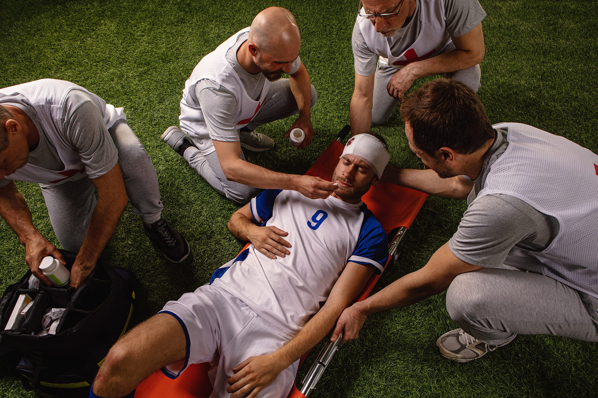 Soccer player down on field on stretcher suffering from a head sports injury.
